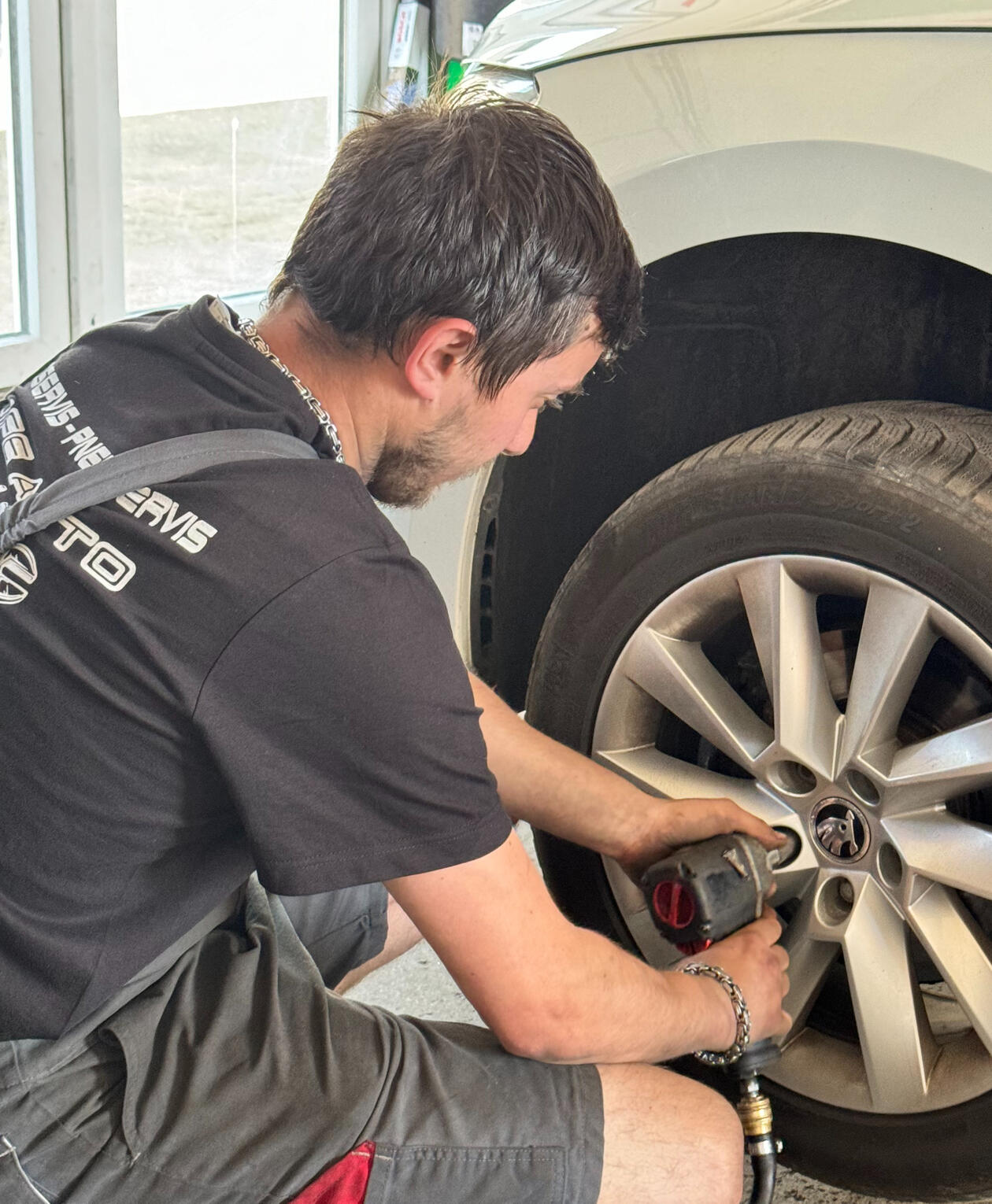 Výmena alu diskov. Muž vymieňa alu disky. Oprava alu diskov. Údržba diskov.